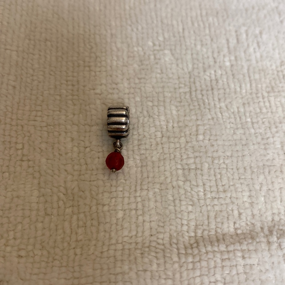 Charm with red hanging stone